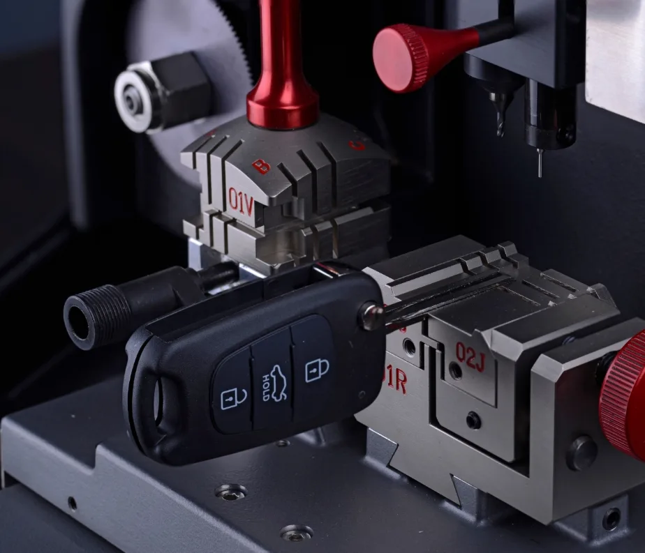 Automotive locksmith cutting replacement car key on mobile key machine