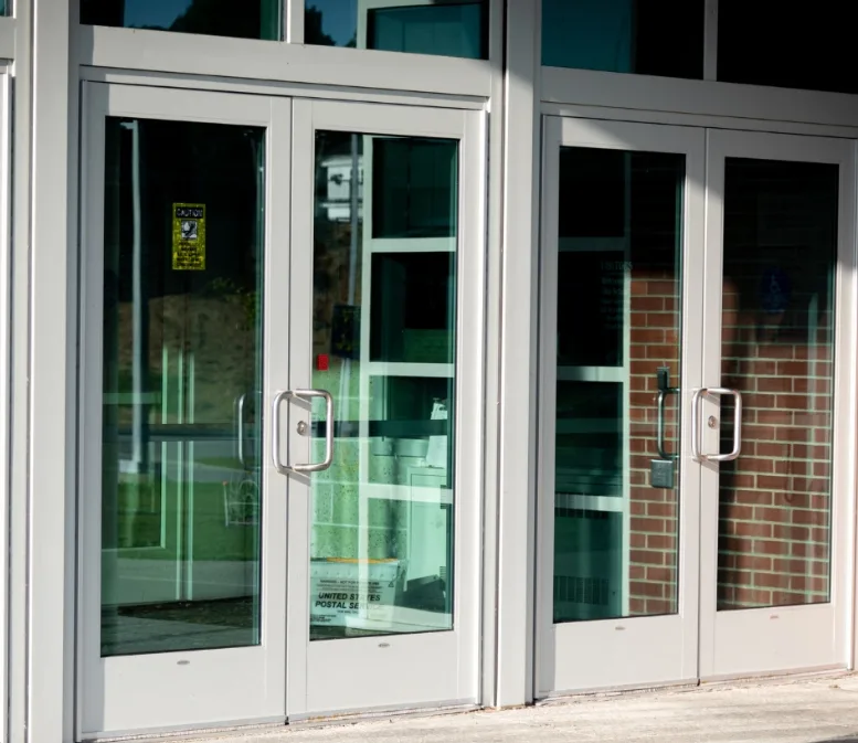 Locksmith checking door gap and alignment with gauge on commercial hollow metal door