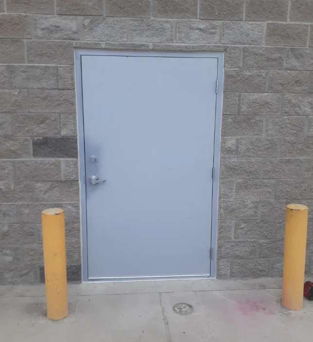 Triton Locksmith repairing corroded hollow metal door bottom edge at commercial building