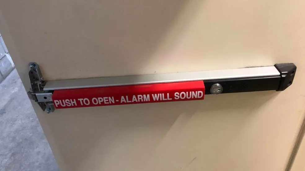 Triton Locksmith installing Von Duprin panic bar exit device on commercial door in South Florida